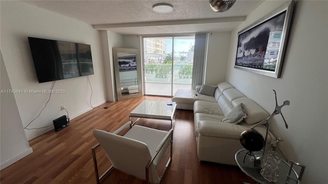 living room with a textured ceiling, wood finished floors, and baseboards