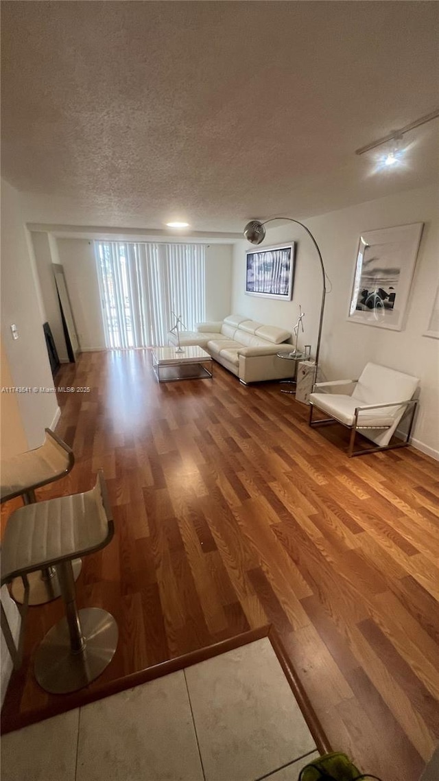 interior space with a textured ceiling and wood finished floors