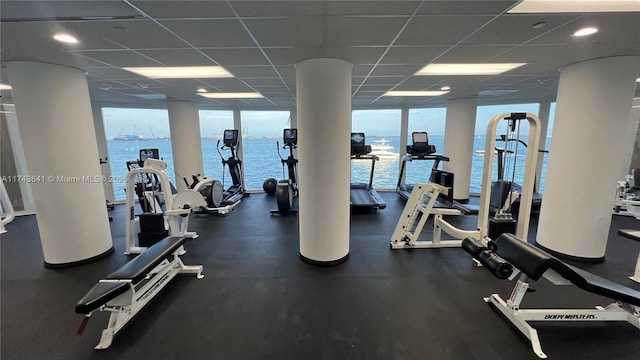 gym featuring a paneled ceiling, a wall of windows, and a wealth of natural light