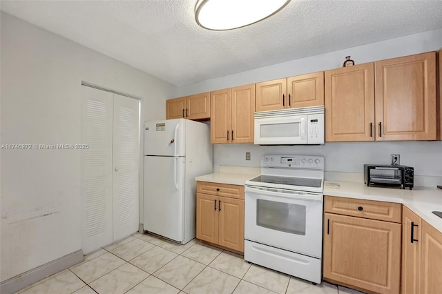 kitchen featuring light tile patterned floors, white appliances, light brown cabinetry, and a textured ceiling