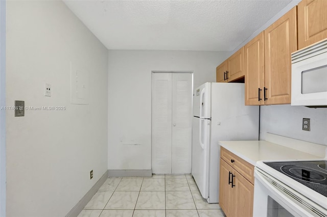 kitchen featuring white appliances, light tile patterned floors, light brown cabinetry, and a textured ceiling