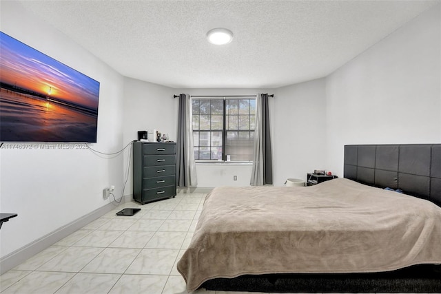 bedroom featuring a textured ceiling and light tile patterned flooring