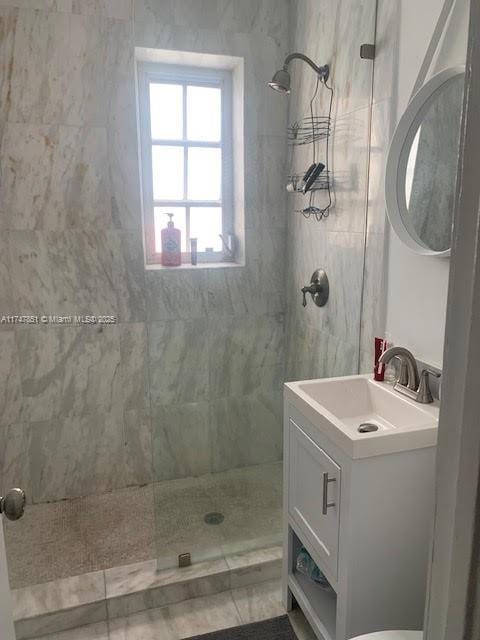 bathroom featuring a tile shower and vanity