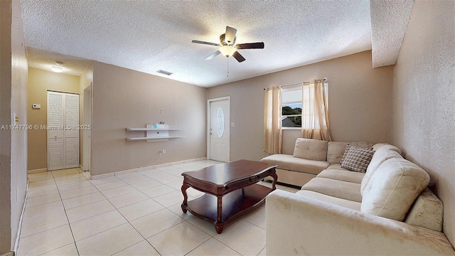 tiled living room with ceiling fan and a textured ceiling