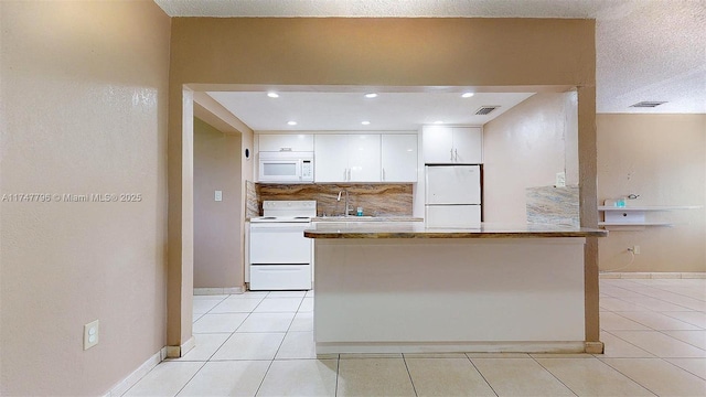 kitchen with sink, backsplash, white appliances, light tile patterned floors, and white cabinets