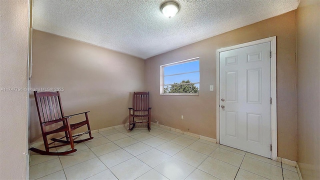 foyer entrance featuring light tile patterned flooring and a textured ceiling