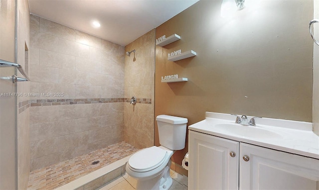 bathroom featuring tiled shower, vanity, toilet, and tile patterned flooring