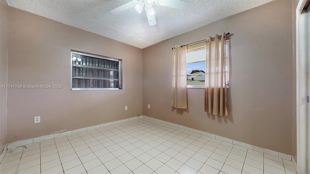 spare room featuring ceiling fan, light tile patterned floors, a textured ceiling, and lofted ceiling