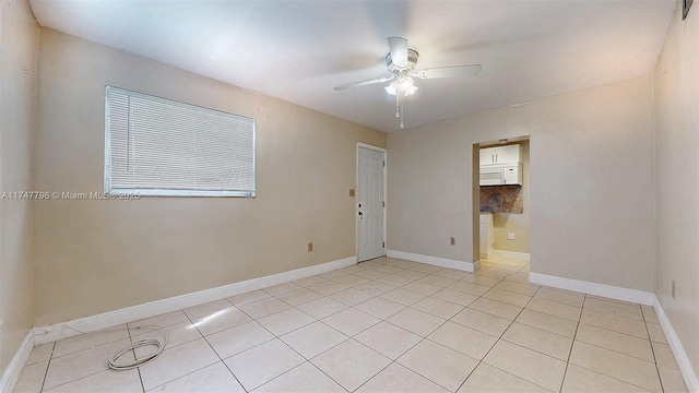 tiled spare room with ceiling fan