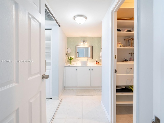 full bathroom with a spacious closet, tile patterned flooring, and vanity