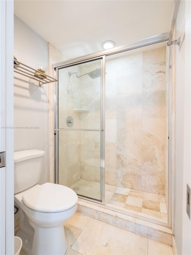 full bathroom featuring tile patterned flooring, a shower stall, and toilet