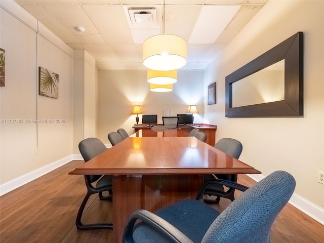 office area featuring a drop ceiling, wood finished floors, visible vents, and baseboards