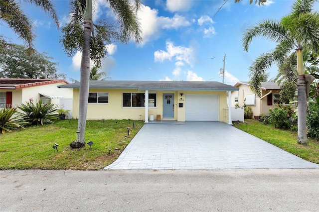 ranch-style home with a garage, decorative driveway, a front lawn, and stucco siding