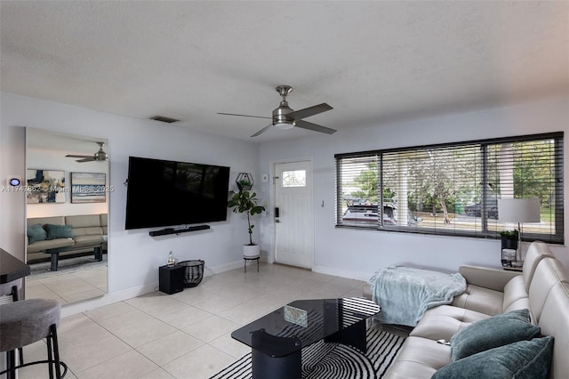 tiled living room featuring ceiling fan and a textured ceiling