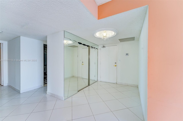 tiled spare room with a textured ceiling