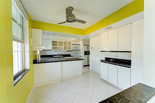 kitchen featuring sink, white appliances, ceiling fan, white cabinets, and decorative backsplash