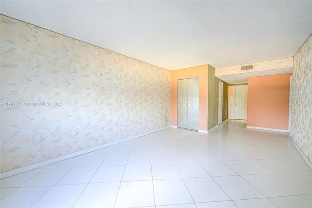 unfurnished room featuring light tile patterned floors and a textured ceiling