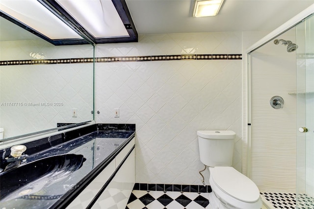 bathroom with tile walls, vanity, toilet, and walk in shower