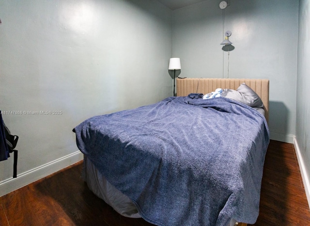 bedroom with dark hardwood / wood-style floors