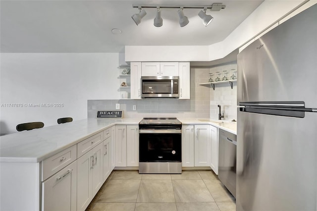 kitchen with sink, backsplash, stainless steel appliances, kitchen peninsula, and white cabinets