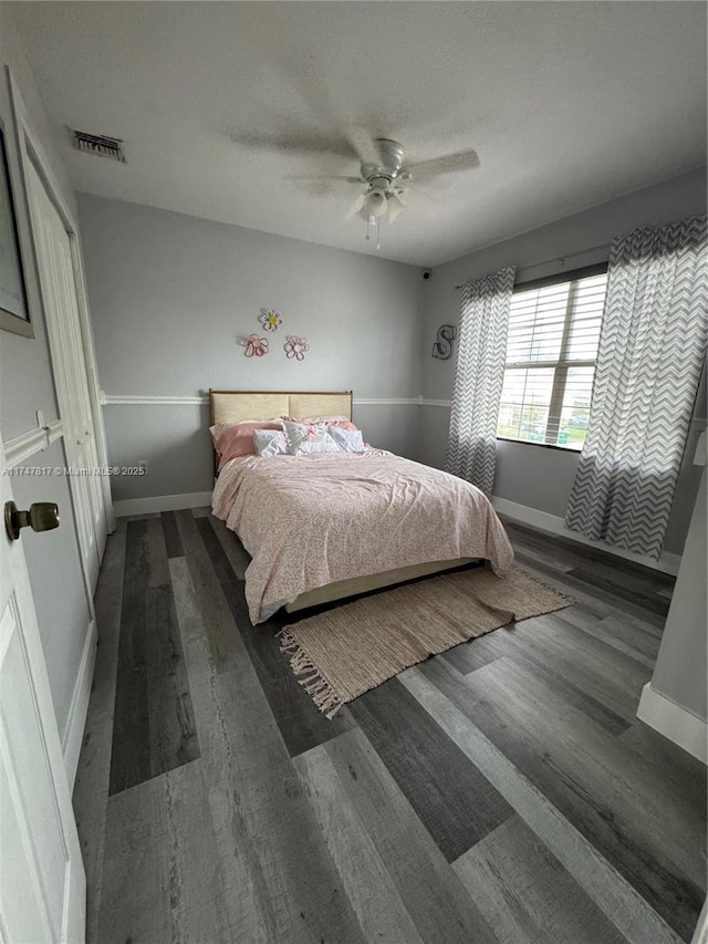 bedroom with dark hardwood / wood-style flooring, ceiling fan, a textured ceiling, and a closet