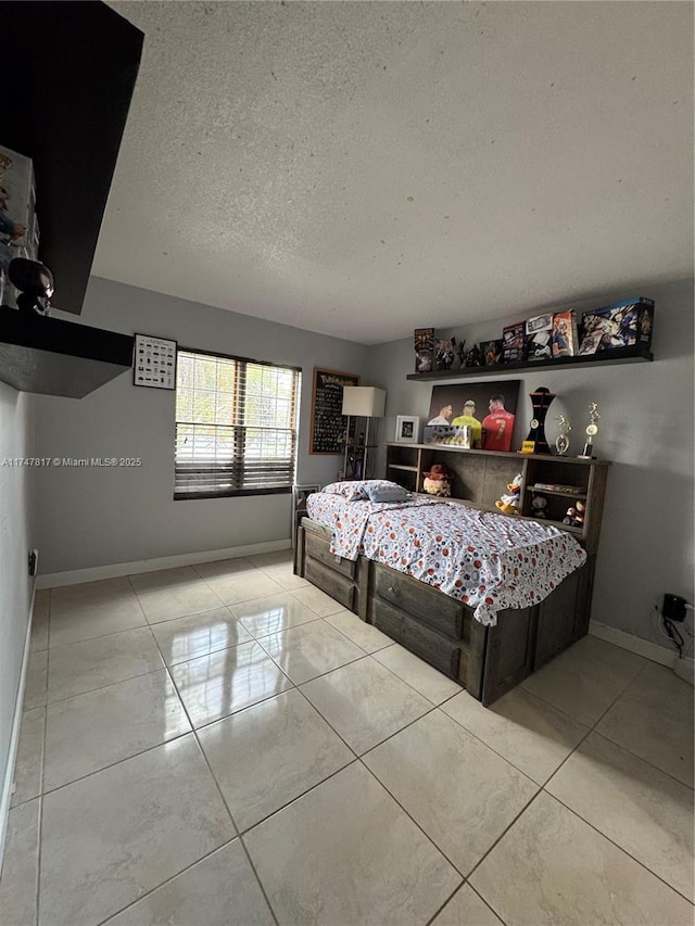 bedroom featuring light tile patterned flooring and a textured ceiling