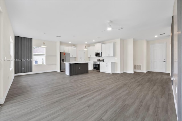 unfurnished living room featuring sink, dark hardwood / wood-style floors, and ceiling fan