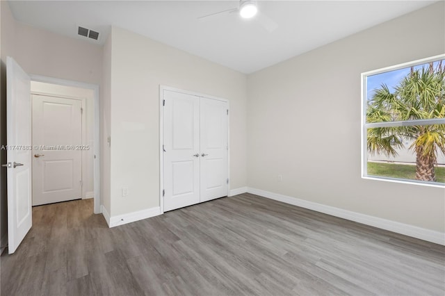 unfurnished bedroom with a closet, ceiling fan, and wood-type flooring