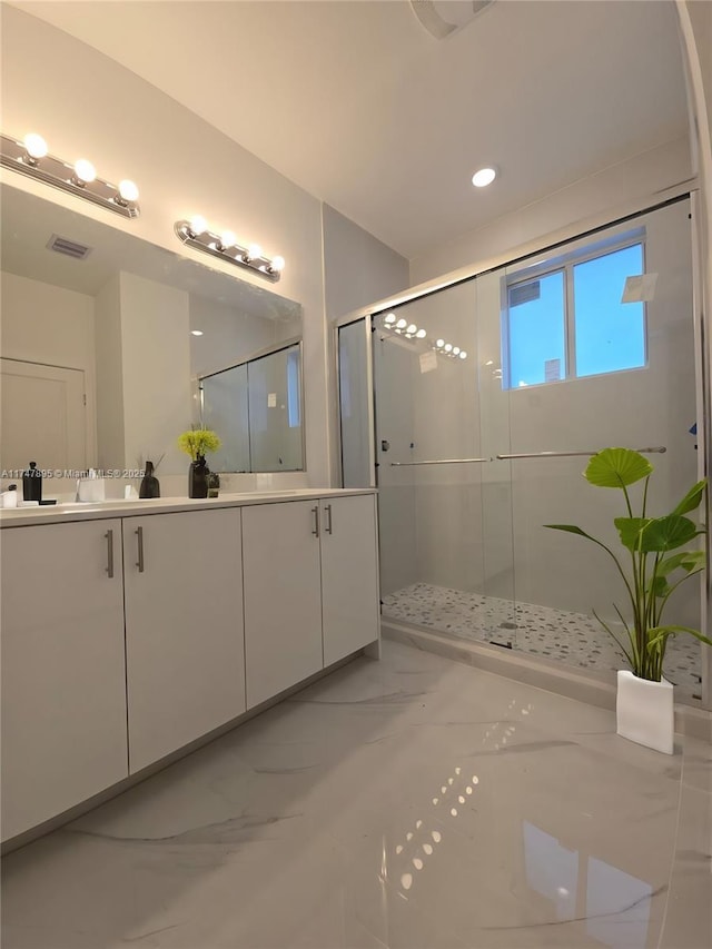 bathroom featuring a shower with door and vanity