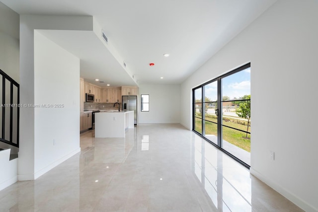 unfurnished living room with recessed lighting, baseboards, visible vents, and a sink