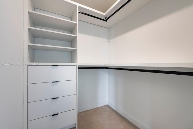 walk in closet with light tile patterned floors