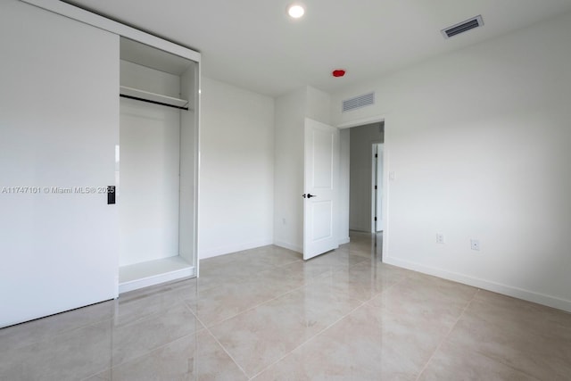 unfurnished bedroom with visible vents, baseboards, and a closet