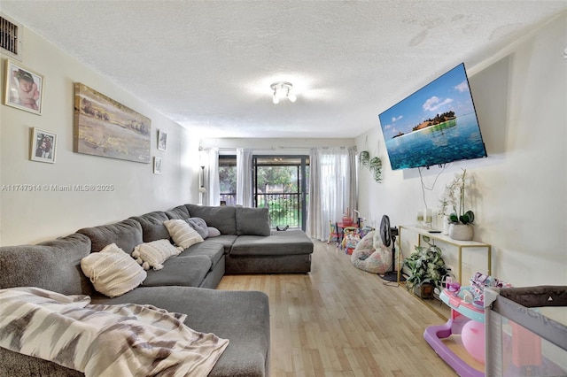 living room with light wood-type flooring and a textured ceiling