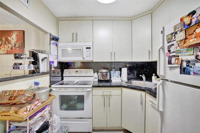 kitchen featuring white appliances, sink, backsplash, and white cabinets