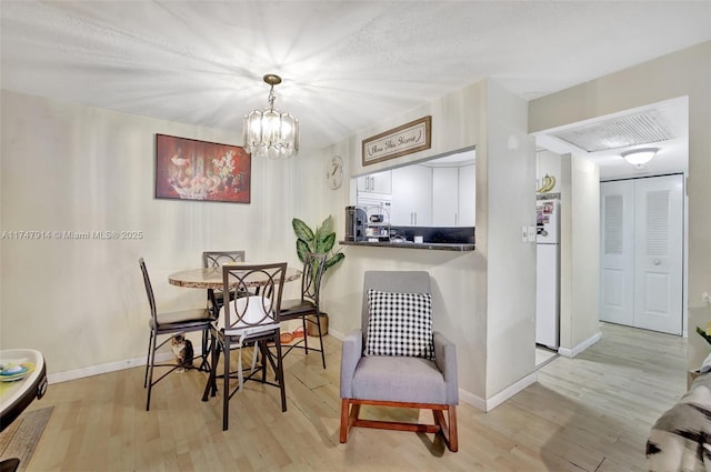 dining area featuring a chandelier and light hardwood / wood-style flooring