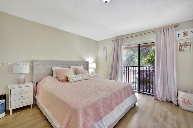 bedroom featuring light hardwood / wood-style flooring, access to exterior, and a textured ceiling