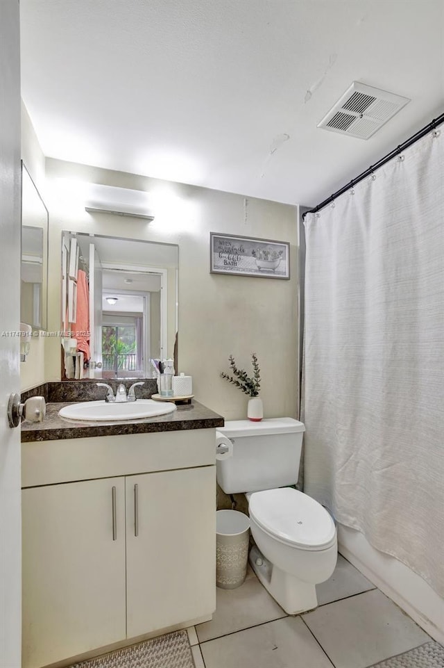 bathroom featuring toilet, tile patterned flooring, and vanity