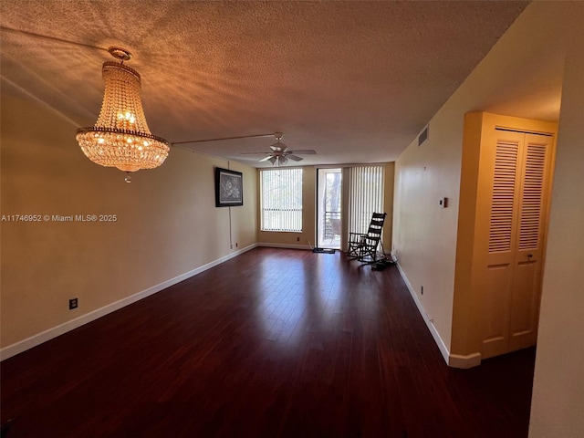 empty room featuring a textured ceiling, dark wood-type flooring, and ceiling fan