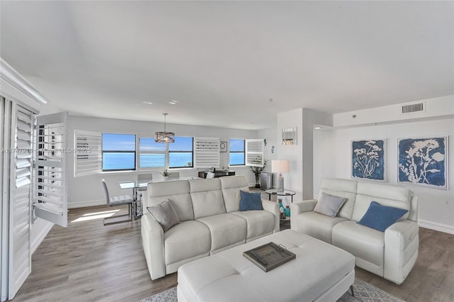 living area featuring baseboards, visible vents, and wood finished floors