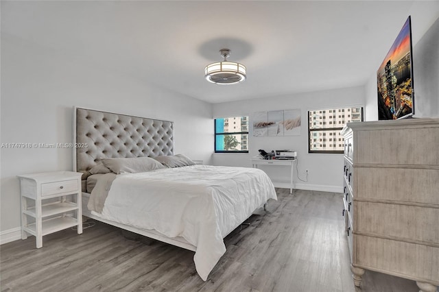 bedroom with baseboards, ceiling fan, and light wood-style floors