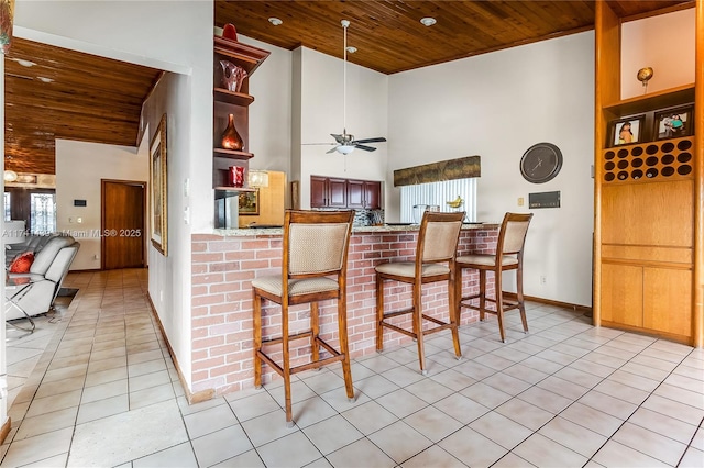 653 NW 110th Ave, Coral Springs, FL 33071 - kitchen featuring kitchen peninsula, wooden ceiling, ceiling fan, light tile patterned floors, and a kitchen bar