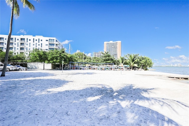 surrounding community featuring a water view, volleyball court, and a beach view