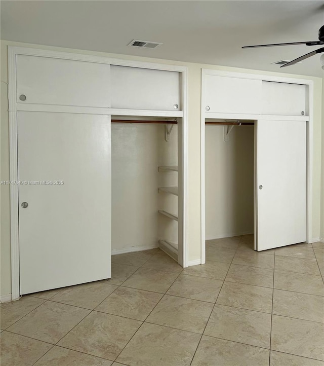 unfurnished bedroom with ceiling fan, multiple closets, visible vents, and light tile patterned floors