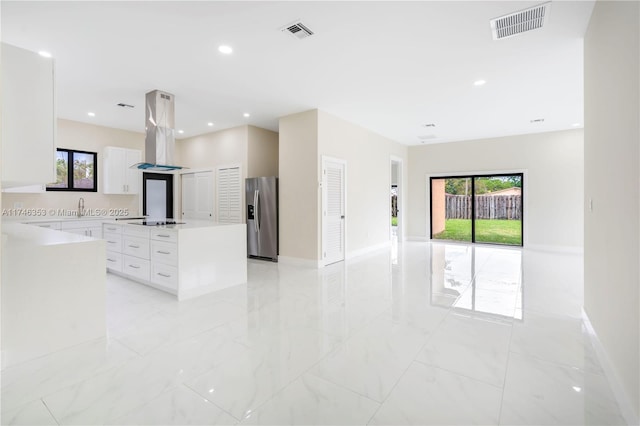 kitchen featuring white cabinetry, stainless steel fridge with ice dispenser, a kitchen island, black electric cooktop, and island range hood