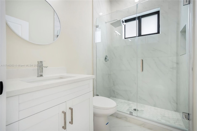 bathroom featuring toilet, vanity, and a shower with door