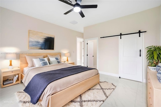 bedroom featuring ceiling fan and a barn door