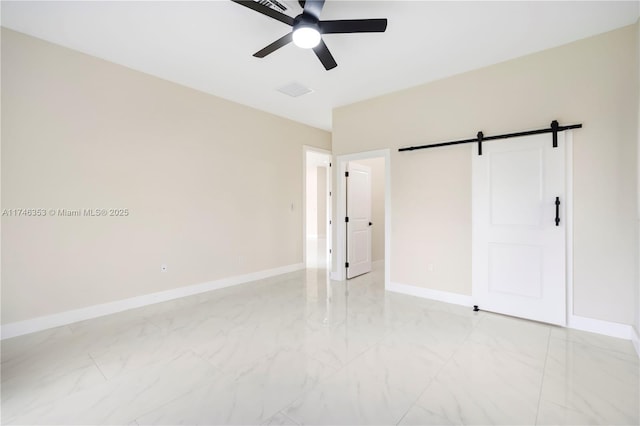 unfurnished bedroom featuring ceiling fan and a barn door