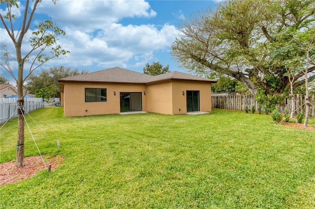 rear view of property featuring a lawn