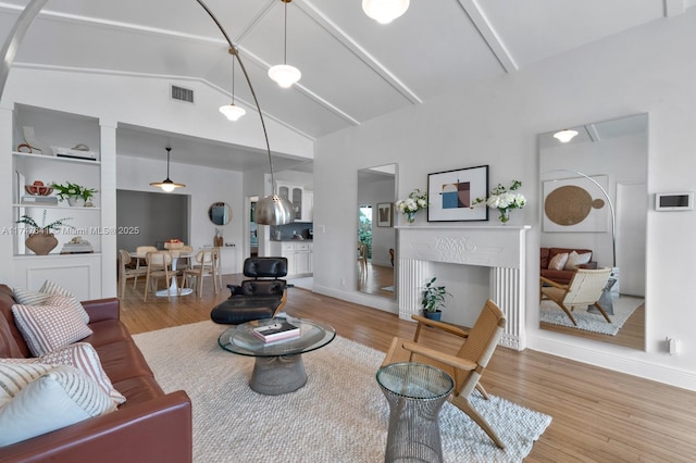 living room with high vaulted ceiling, beamed ceiling, and wood-type flooring