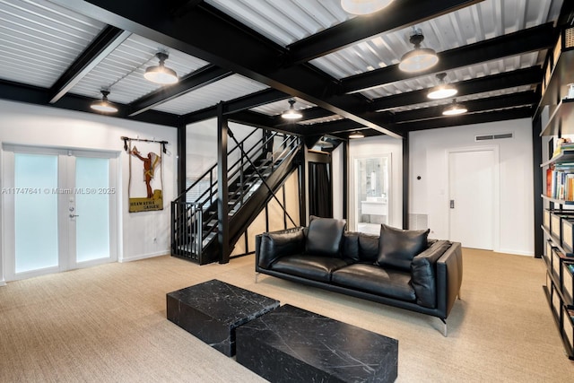 carpeted living room with beamed ceiling